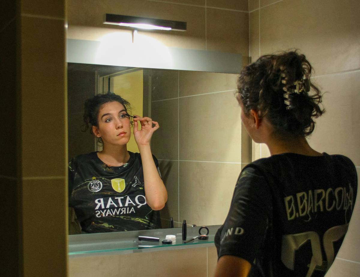 A woman using a well-lit makeup mirror essential with adjustable LED panels showing true skin tone